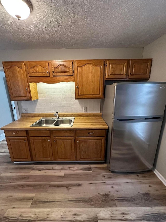 662 Frederick St, Lancaster, OH 43130 - kitchen with freestanding refrigerator, a sink, wood finished floors, light countertops, and a textured ceiling