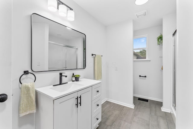 507 Brumfield Rd, Lancaster, OH 43130 - full bathroom featuring vanity, wood finished floors, a shower with door, and baseboards