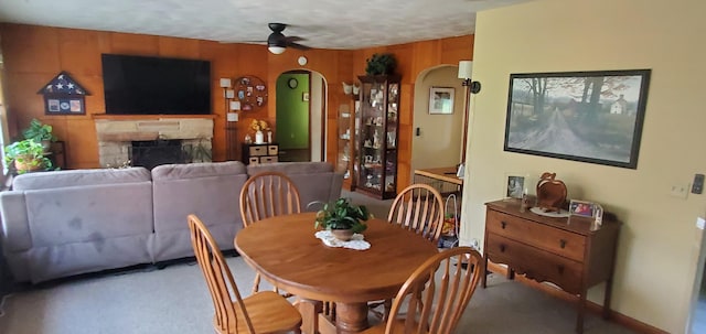 207 Newton Ave, Newark, OH 43055 - dining space featuring arched walkways, a ceiling fan, carpet floors, and a stone fireplace