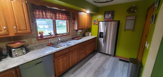 207 Newton Ave, Newark, OH 43055 - kitchen with stainless steel appliances, a sink, light countertops, light wood-style flooring, and brown cabinets