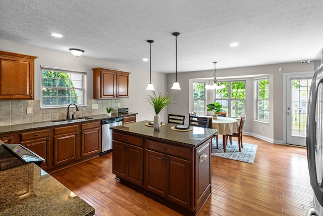 1245 Little Bear Loop, Lewis Center, OH 43035 - kitchen featuring stainless steel appliances, a sink, hardwood / wood-style flooring, decorative backsplash, and a textured ceiling