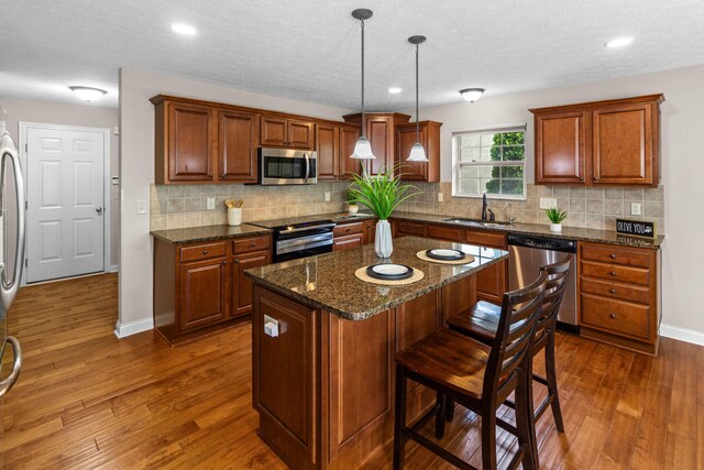 1245 Little Bear Loop, Lewis Center, OH 43035 - kitchen featuring appliances with stainless steel finishes, a sink, dark wood-type flooring, baseboards, and a kitchen breakfast bar