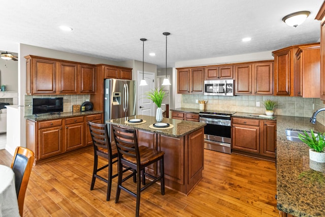 1245 Little Bear Loop, Lewis Center, OH 43035 - kitchen featuring appliances with stainless steel finishes, a sink, a center island, backsplash, and dark wood-style floors