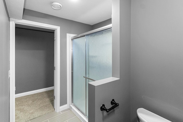1245 Little Bear Loop, Lewis Center, OH 43035 - bathroom featuring a stall shower, toilet, and baseboards