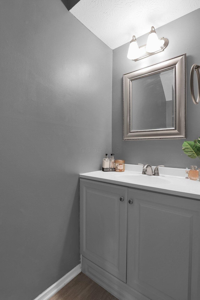 3195 Summerdale Ln, Columbus, OH 43221 - bathroom with vanity, wood finished floors, and baseboards