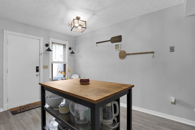 3195 Summerdale Ln, Columbus, OH 43221 - dining room with wood finished floors, baseboards, a textured ceiling, and a chandelier
