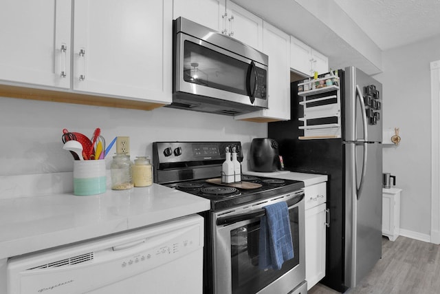 3195 Summerdale Ln, Columbus, OH 43221 - kitchen featuring appliances with stainless steel finishes, light wood-style floors, white cabinets, light countertops, and a textured ceiling