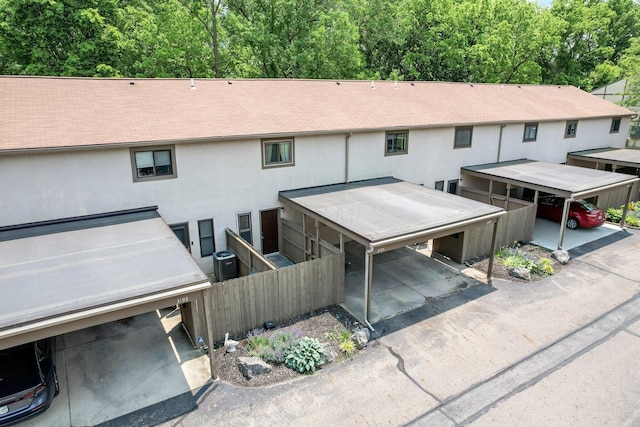 3195 Summerdale Ln, Columbus, OH 43221 - back of property featuring stucco siding, a shingled roof, central AC, and a carport