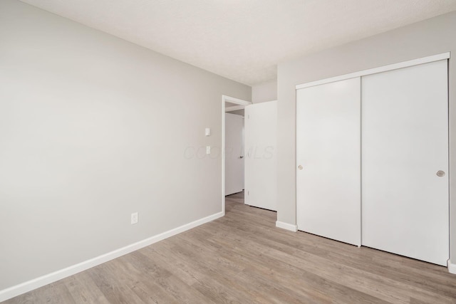 133 Blendon Rd, West Jefferson, OH 43162 - unfurnished bedroom with light wood finished floors, baseboards, and a closet