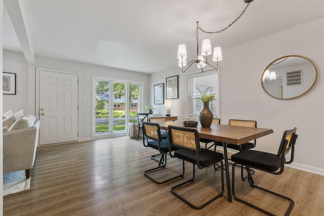 895 Caniff Rd, Columbus, OH 43221 - dining area with a chandelier, baseboards, and wood finished floors