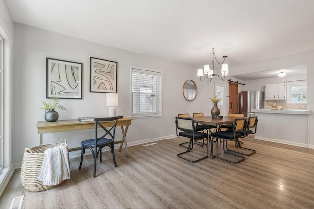 895 Caniff Rd, Columbus, OH 43221 - dining area with light wood-style floors, a chandelier, and baseboards