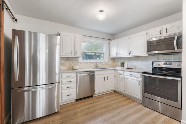 895 Caniff Rd, Columbus, OH 43221 - kitchen featuring stainless steel appliances, a sink, light wood-style floors, light countertops, and white cabinets