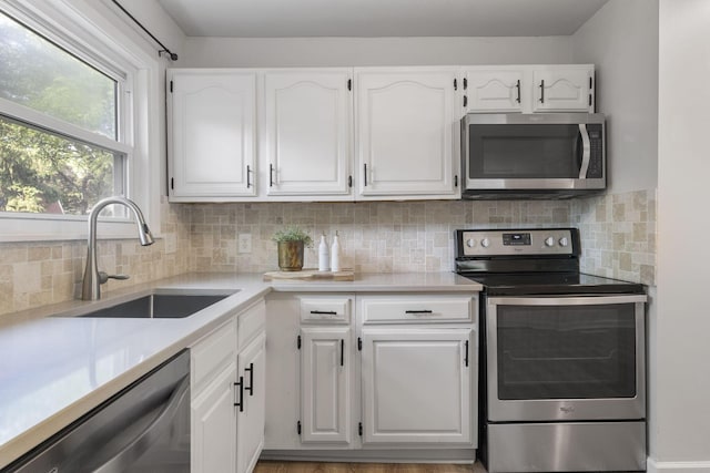 895 Caniff Rd, Columbus, OH 43221 - kitchen with appliances with stainless steel finishes, a sink, white cabinets, and tasteful backsplash