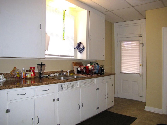236 E Lane Ave, Columbus, OH 43201 - kitchen with dark countertops, white cabinetry, plenty of natural light, and a paneled ceiling