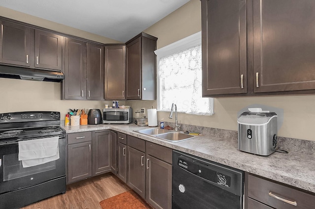 1598 Metcalfe Ave, Obetz, OH 43207 - kitchen with black appliances, a sink, under cabinet range hood, light wood-type flooring, and dark brown cabinetry