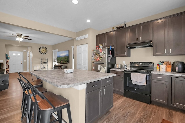 1598 Metcalfe Ave, Obetz, OH 43207 - kitchen with electric range, freestanding refrigerator, under cabinet range hood, wood finished floors, and recessed lighting