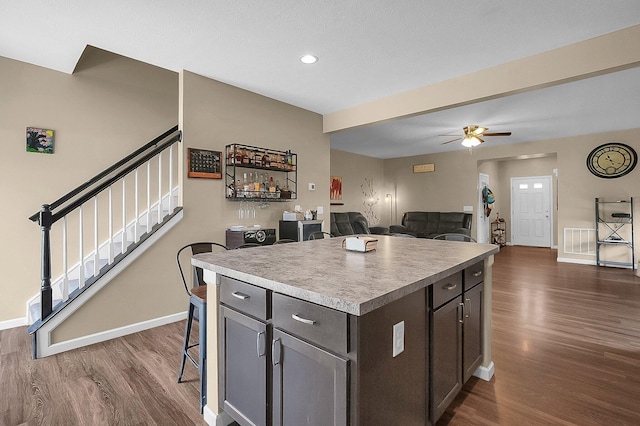 1598 Metcalfe Ave, Obetz, OH 43207 - kitchen featuring dark wood-style floors, a breakfast bar area, baseboards, a kitchen island, and recessed lighting
