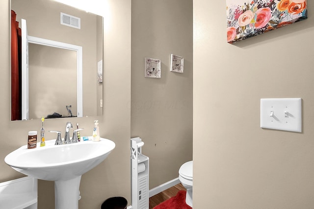 1598 Metcalfe Ave, Obetz, OH 43207 - half bath with toilet, wood finished floors, baseboards, and a sink