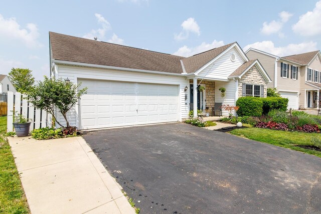 91 Richard Ave, South Bloomfield, OH 43103 - view of front facade with asphalt driveway, a garage, and stone siding
