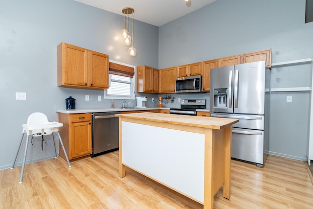 91 Richard Ave, South Bloomfield, OH 43103 - kitchen featuring appliances with stainless steel finishes, butcher block countertops, light wood-style floors, a towering ceiling, and pendant lighting