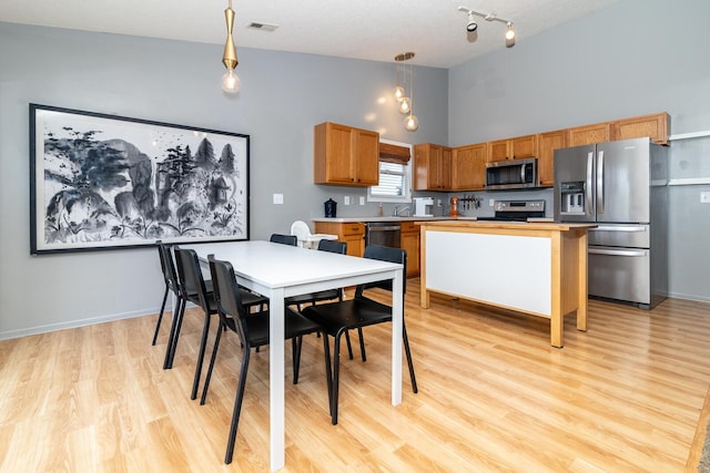 91 Richard Ave, South Bloomfield, OH 43103 - dining space with light wood-type flooring, high vaulted ceiling, track lighting, and baseboards