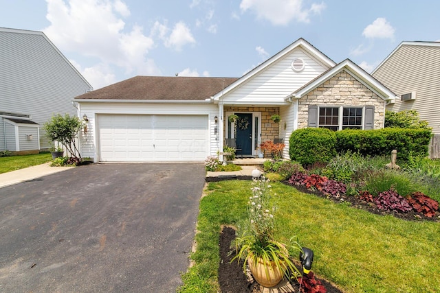 91 Richard Ave, South Bloomfield, OH 43103 - view of front of home featuring driveway, stone siding, an attached garage, and a front lawn