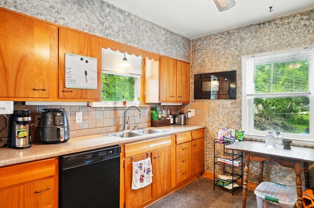 2506 Chester Rd, Columbus, OH 43231 - kitchen with black dishwasher, a sink, healthy amount of natural light, and light countertops