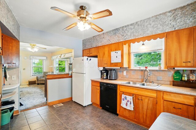 2506 Chester Rd, Columbus, OH 43231 - kitchen with black dishwasher, a sink, ceiling fan, freestanding refrigerator, and decorative backsplash