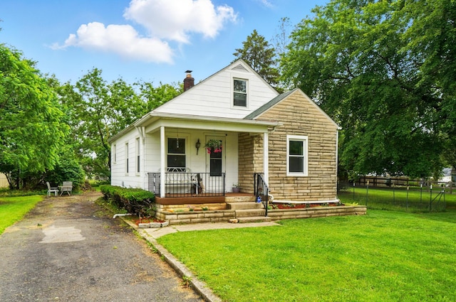 2506 Chester Rd, Columbus, OH 43231 - bungalow with a porch, stone siding, a chimney, and asphalt driveway