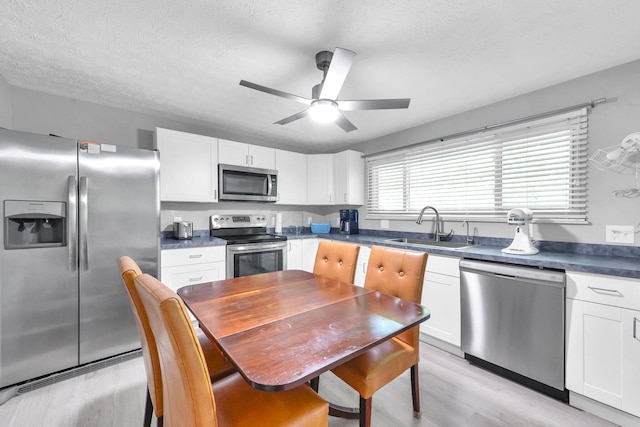 563 Wickham Way, Gahanna, OH 43230 - kitchen with appliances with stainless steel finishes, light wood-type flooring, white cabinets, ceiling fan, and a textured ceiling
