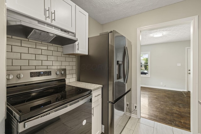 2592 Grasmere Ave, Columbus, OH 43211 - kitchen featuring electric range oven, under cabinet range hood, a textured ceiling, decorative backsplash, and white cabinets