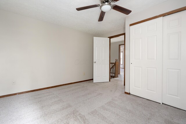 7552 Deer Creek Dr, Columbus, OH 43085 - unfurnished bedroom featuring light carpet, a textured ceiling, baseboards, a closet, and a ceiling fan
