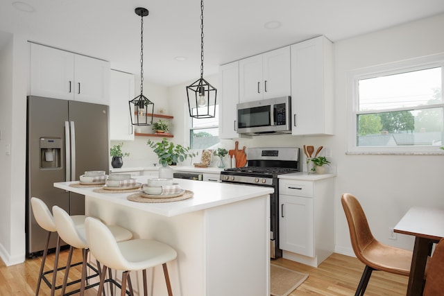 1079 Loring Rd, Columbus, OH 43224 - kitchen with appliances with stainless steel finishes, light wood-style flooring, a kitchen breakfast bar, and healthy amount of natural light