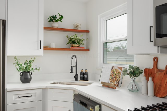 1079 Loring Rd, Columbus, OH 43224 - kitchen with dishwasher, a sink, open shelves, white cabinetry, and stainless steel microwave