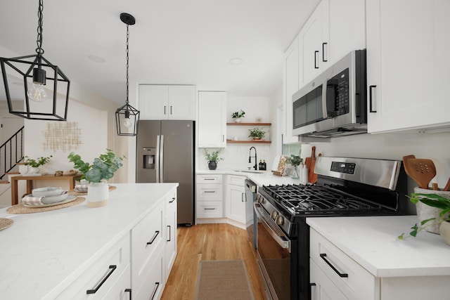 1079 Loring Rd, Columbus, OH 43224 - kitchen featuring appliances with stainless steel finishes, light wood-type flooring, decorative light fixtures, open shelves, and light countertops