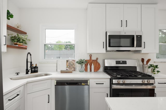 1079 Loring Rd, Columbus, OH 43224 - kitchen featuring stainless steel appliances, a sink, white cabinetry, and open shelves