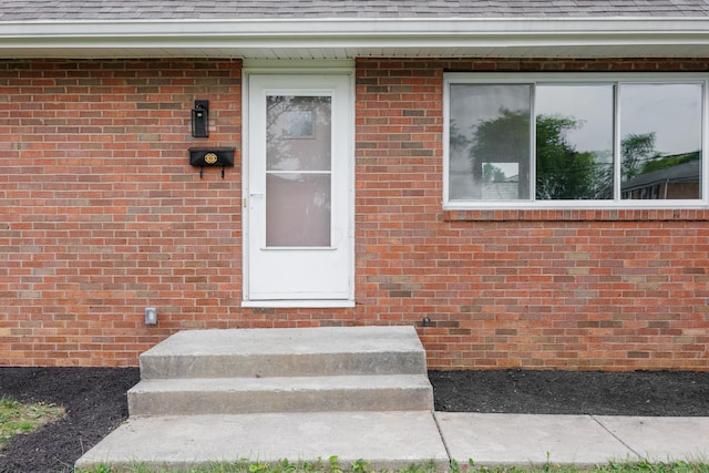 1079 Loring Rd, Columbus, OH 43224 - view of exterior entry featuring a shingled roof and brick siding