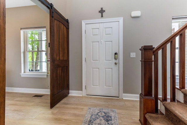 405 Tyler Station Dr, Johnstown, OH 43031 - entrance foyer featuring stairs, light wood-style flooring, a barn door, and baseboards