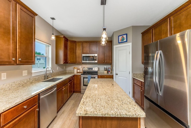 405 Tyler Station Dr, Johnstown, OH 43031 - kitchen with appliances with stainless steel finishes, a sink, light wood-type flooring, a center island, and hanging light fixtures