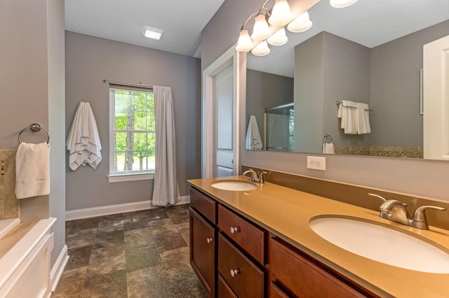 405 Tyler Station Dr, Johnstown, OH 43031 - full bathroom featuring baseboards, double vanity, stone finish flooring, a shower, and a tub to relax in