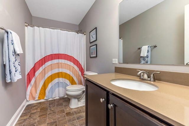 405 Tyler Station Dr, Johnstown, OH 43031 - full bathroom featuring vanity, toilet, stone finish flooring, a shower with curtain, and baseboards