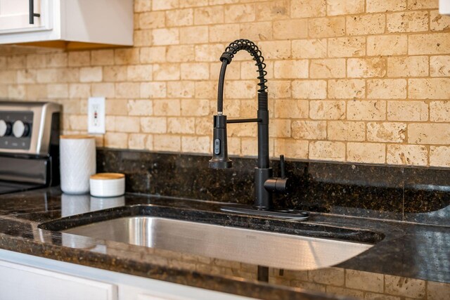 1116 Summit St Unit 1114, Columbus, OH 43201 - kitchen view of a sink, white cabinets, backsplash, and dark stone counters