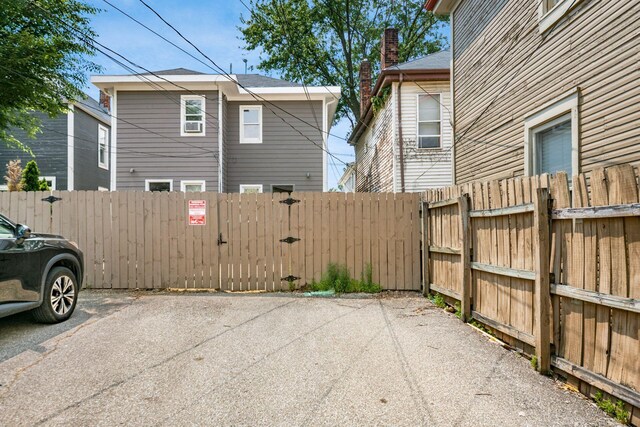 1116 Summit St Unit 1114, Columbus, OH 43201 - view of side of property featuring a gate, uncovered parking, and a chimney