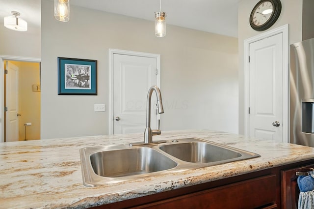 6368 Casado Dr, Columbus, OH 43213 - kitchen with a sink, light stone counters, decorative light fixtures, and stainless steel fridge with ice dispenser