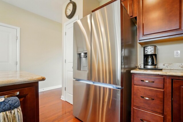 6368 Casado Dr, Columbus, OH 43213 - kitchen featuring stainless steel fridge, wood finished floors, light stone counters, and baseboards