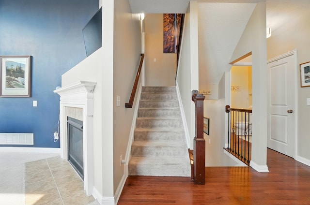 6368 Casado Dr, Columbus, OH 43213 - stairway featuring wood finished floors, baseboards, and a glass covered fireplace