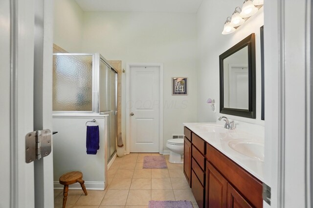 6368 Casado Dr, Columbus, OH 43213 - full bathroom featuring double vanity, tile patterned flooring, a stall shower, and toilet