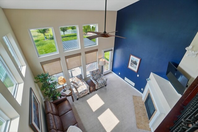 6368 Casado Dr, Columbus, OH 43213 - carpeted living room featuring a towering ceiling, a fireplace, and a ceiling fan