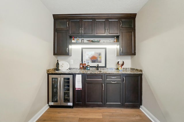 6368 Casado Dr, Columbus, OH 43213 - indoor wet bar with wine cooler, baseboards, and light wood-type flooring