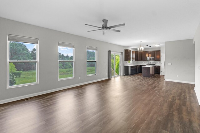 3015 Green Line Way, Columbus, OH 43231 - unfurnished living room featuring dark wood-style floors, baseboards, a ceiling fan, a chandelier, and a sink